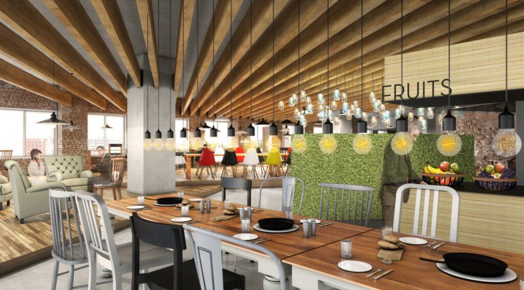 Modern cafeteria with food display counter and a chef at work in the kitchen area.