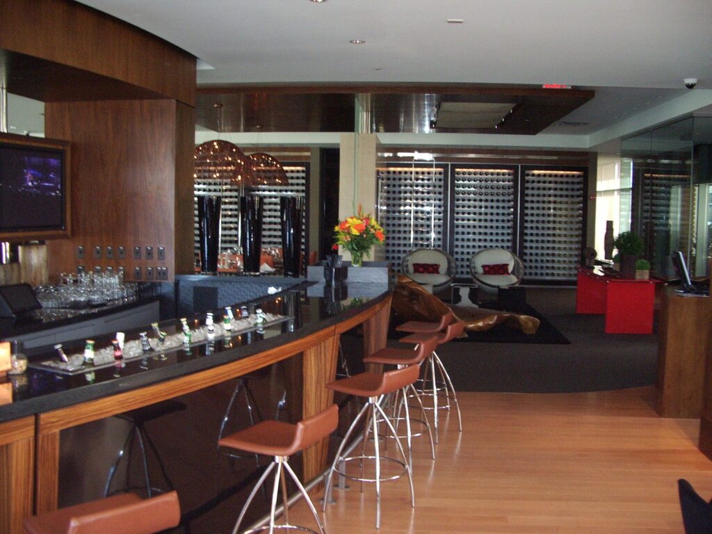 Modern cafeteria with food display counter and a chef at work in the kitchen area.